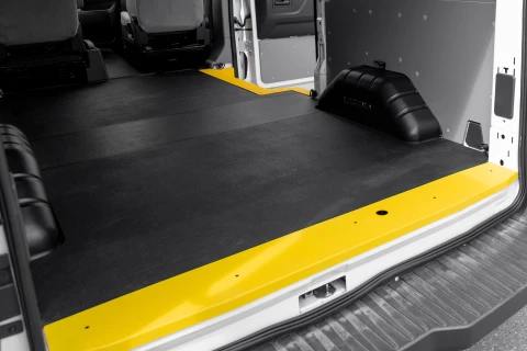 An image showing a lightweight no-drill flooring called EVOLVE, designed for EV vehicles. The floor also has yellow sills for cargo van safety.